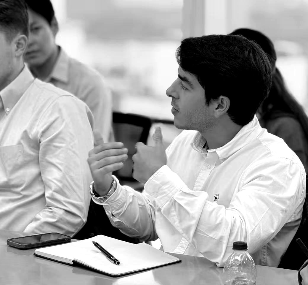 Luis Enrique Blas Barba making a point in a meeting, black and white photo